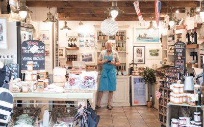 a-man-running-his-small-deli-stall-shop-at-a-local-fresh-food-produce-market-selling-cheese-jamp-and_t20_6l00rY