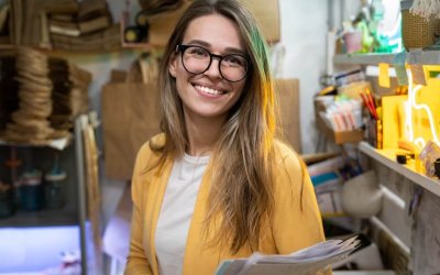 successful-small-business-owner-in-casual-wearing-yellow-cardigan-standing-in-her-store-looking-at_t20_G0BJEm